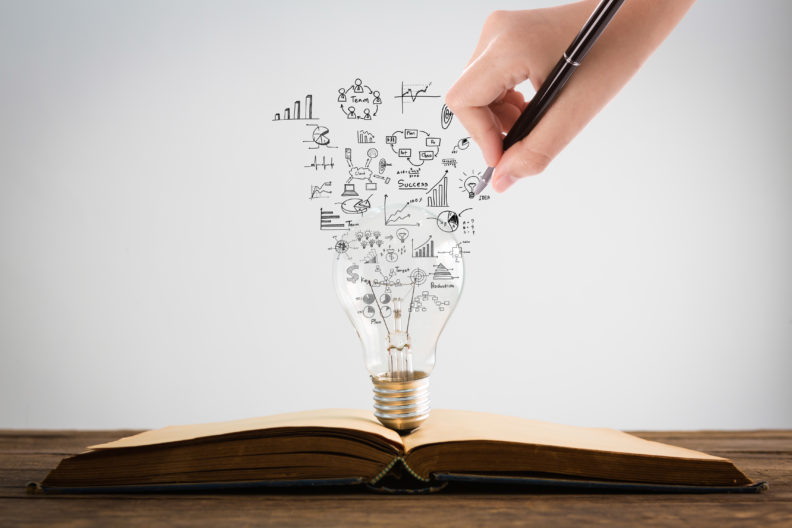 Book and light bulb with hand drawing graph